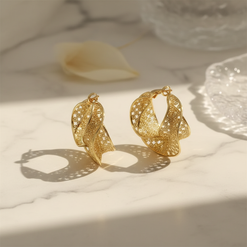 Textured gold twisted hoops on marble